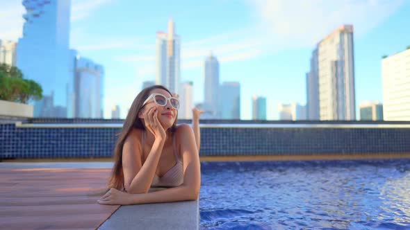 Young asian woman enjoy around outdoor swimming pool for leisure