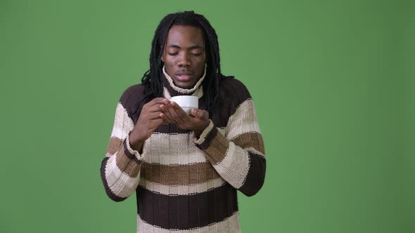 Young Handsome African Man with Dreadlocks Against Green Background