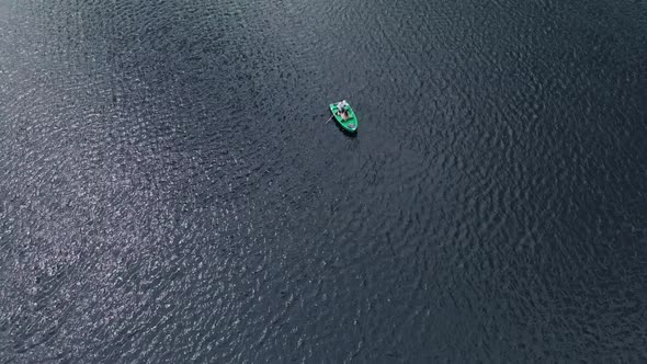 Drone Shooting of a Young Girl and a Man in a Rowboat Surrounded By Water By Ripples on the Surface