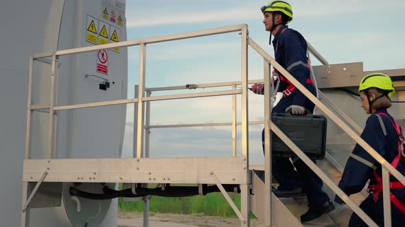 Two maintenance engineers in safety gear working at height walking to the maintenance station