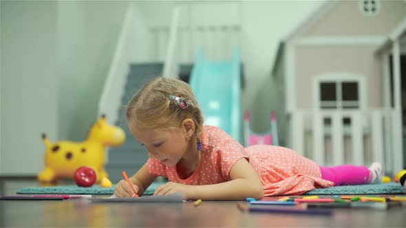 Preschooler Girl Drawing with Crayons on a Floor