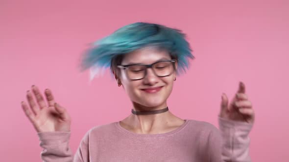 Unusual Woman with Blue Hair Having Fun, Smiling, Dancing with Head in Studio