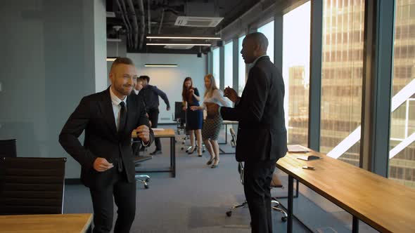 Caucasian and Aframerican Employees Dancing at Coworking Office