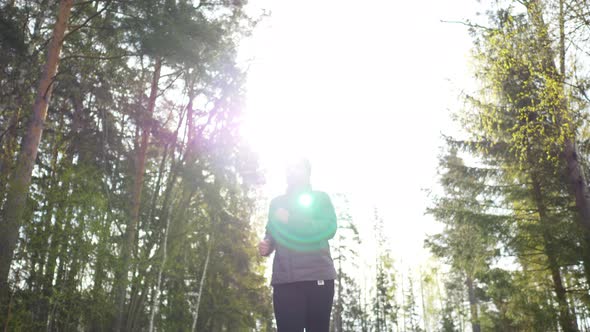 Asian woman wearing coat and going jogging in the forest to see a beautiful nature in the morning