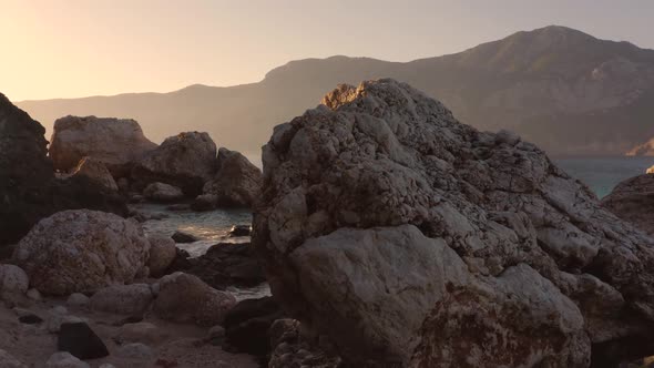 Beautiful Rocky Cliffs and Clear Ocean Water with Mountains in the Background