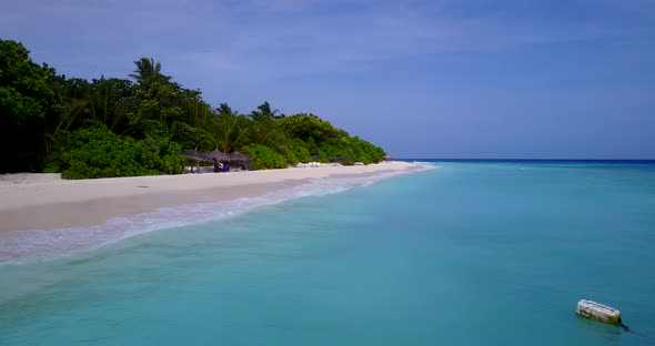 Luxury fly over island view of a white paradise beach and blue water background in vibrant 4K