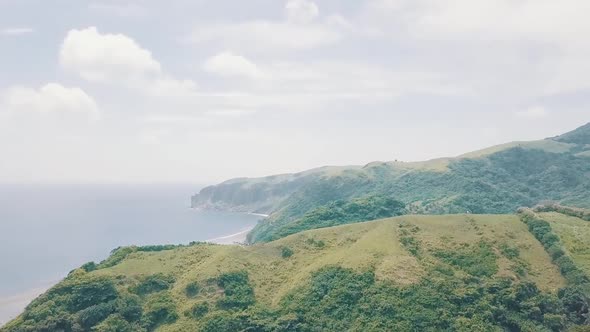 Cinematic aerial drone view of a picturesque landscape of ocean meeting mountains in Batanes, Philip