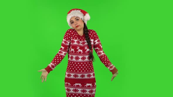 Sweety Girl in Santa Claus Hat Upset Is Shrugging and Sighing. Green Screen