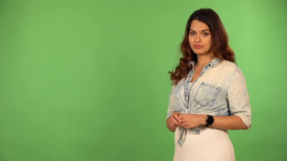 A Young Beautiful Caucasian Woman Taps at Her Watch and Looks at the Camera  Green Screen