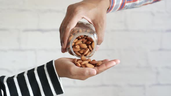 Pouring Almond Nuts on Hand
