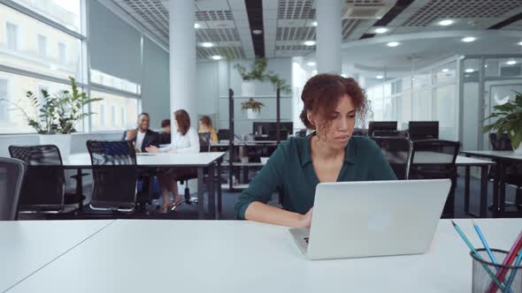 Black Woman Using Laptop in Coworking Space