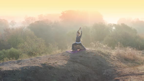 Yoga Girl Practicing Pilates on Top of the Hill