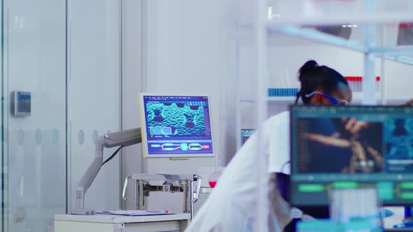 Black Young Scientist Working in Busy Modern Laboratory