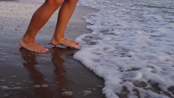 Beautiful woman in a white dress at the beach at sunset