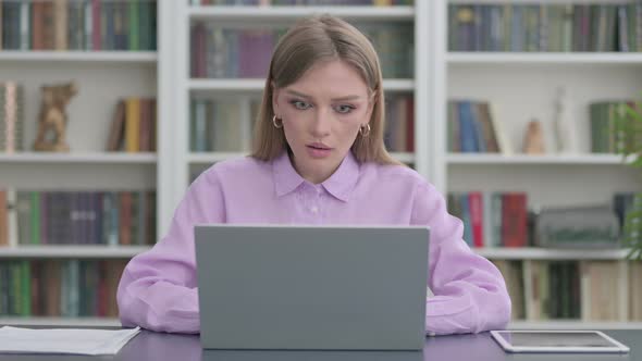 Woman Celebrating Success While Using Laptop in Office