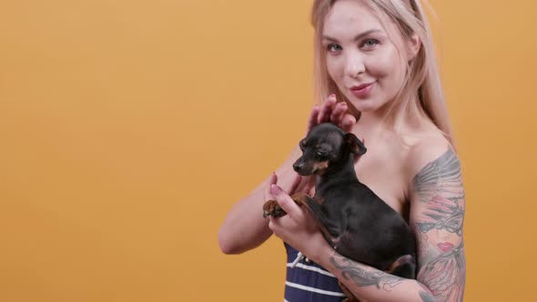 Portrait of a Sensual Tattooed Blonde Girl and Her Pet