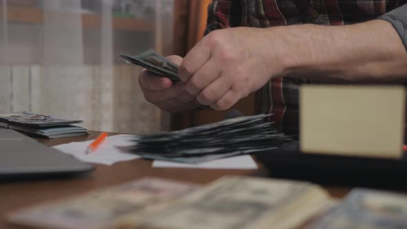 Retired Man Considers Cash on Costs  Male Hand with Money Closeup Planning the Family Budget