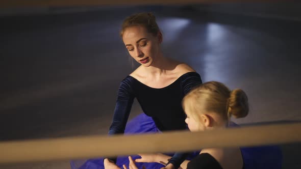 Portrait of Professional Graceful Slim Ballerina Talking with Girl Explaining Ballet Hands Positions
