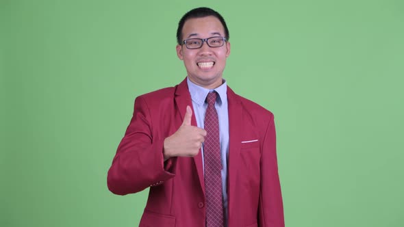 Happy Asian Businessman with Eyeglasses Giving Thumbs Up