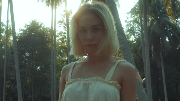 Young Blonde Standing Contemplating Tropical Rainforest Sunset Light Coming From Above