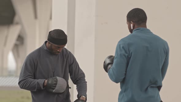 Young Black Man Having Outdoor Boxing Training with Coach