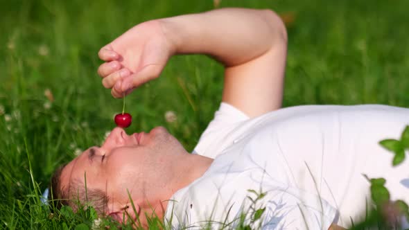 Young Man Resting Lying on the Grass in the Garden