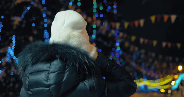 Woman Walks Through the City at Night in the Lights in the Winter