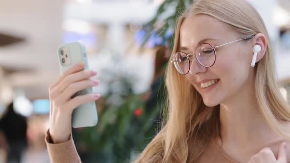 Young Millennial Girl Make Video Call in Mall Wave Hand Say Hello Friend Smiling Female in Wireless