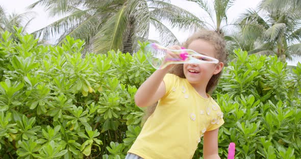 Cute Caucasian Kid Child Happily Blowing Soap Bubbles in a Park