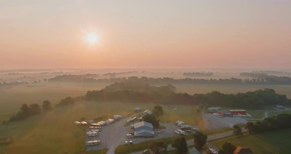 Rural Landscape at Sunrise with Road in a Field on a Foggy Spring Morning