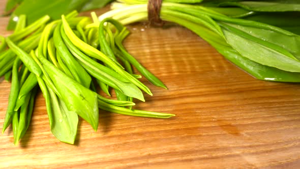 Wild garlic leaves on a wooden cutting board.