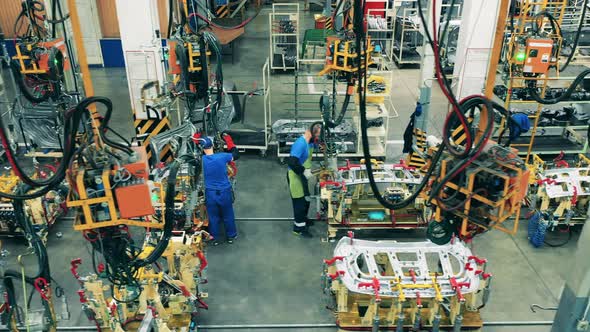 Car Factory Workers Using Modern Welding Machines To Weld Car Parts