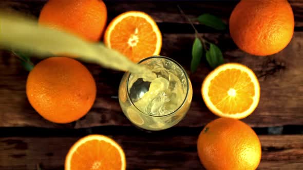 Super Slow Motion in the Glass Whirlpool Pours Orange Juice