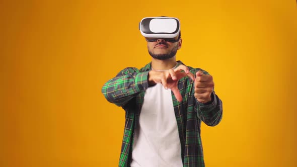 Casual African American Man Using VR Technology Wearing Headset Against Yellow Background