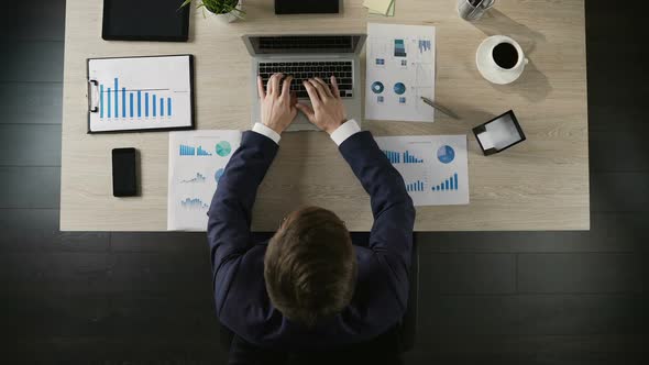 Man Finishing Project and Closing Laptop Computer at Workplace, Top View