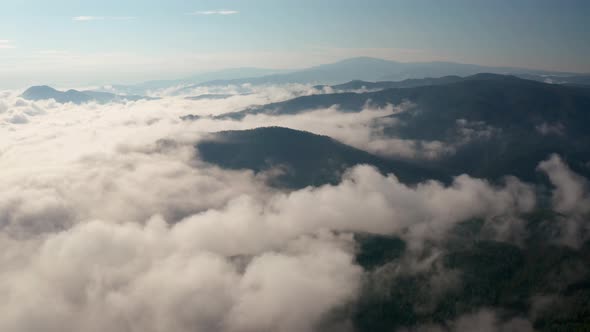 Drone flight over low clouds and morning mists