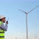 An engineer with a walkie-talkie near the wind generator. - VideoHive Item for Sale