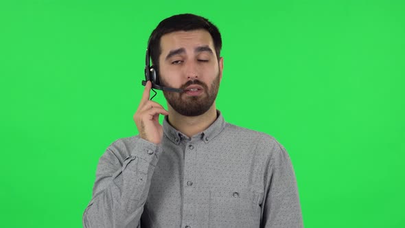 Portrait of Brunette Guy Is Talking on Headphones, Call Center. Green Screen