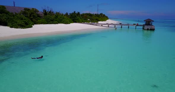 Wide birds eye clean view of a white sand paradise beach and aqua turquoise water background 