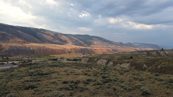 Vast, dry mountainous landscapes of the Okanagan being illuminated by the evening sun. Wide angle pa