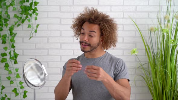 Portrait of young man applying eye pad under eye