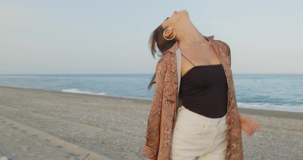 Young girl with black boots has fun on the beach near the sea in Italy