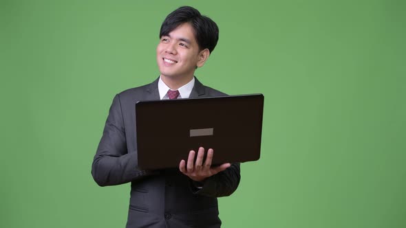 Young Handsome Asian Businessman Using Laptop