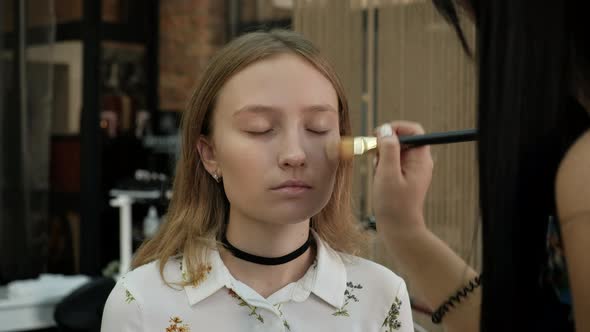 the Make-Up Stylist Doing a Make-Up to Hipster Model