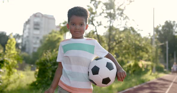 Cute Black Boy Holding a Soccer Ball at Playground