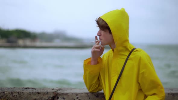 Teenager Smoking on Shore Looks Back Wind Slomo