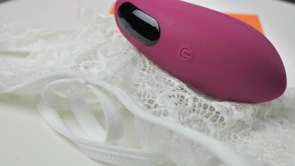 The Clitoral Vaginal Vibrator is Spinning on a White Plate