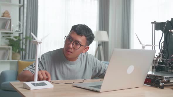 Kid Or Student With Laptop Computer Programming Electric Windmill Toy At Home