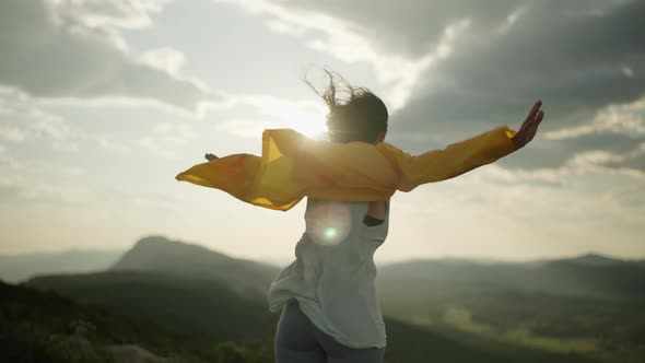 The Girl Raises Her Hands to the Top of the Mountain and Feels Freedom