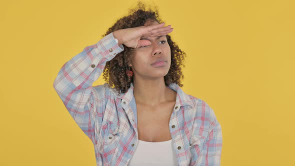 Young African Woman Looking Around Searching Yellow Screen